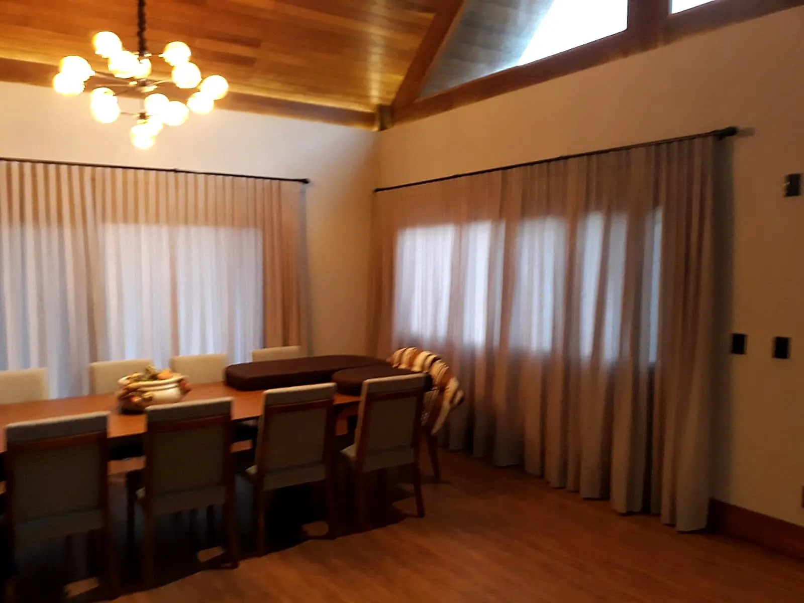 Cortina em trilho — voil cinza — Sala de jantar com pé-direito de madeira
