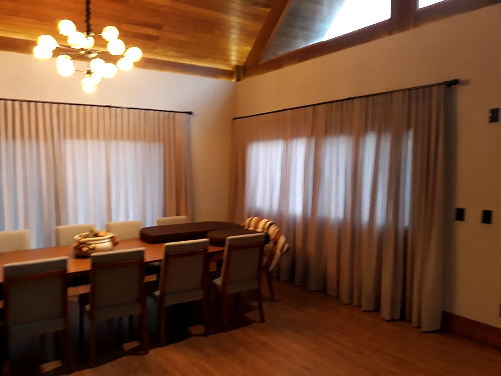 Cortina em trilho — voil cinza — Sala de jantar com pé-direito de madeira
